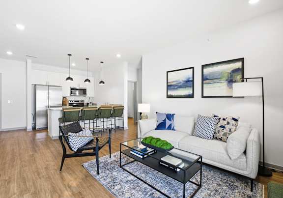 A living room with a couch, a table, and a painting on the wall.