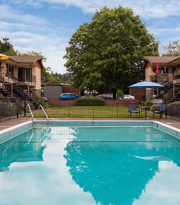A swimming pool in front of apartment buildings.
