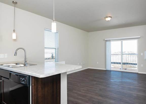 A kitchen with a white countertop and black appliances.