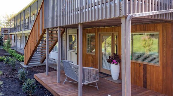 A wooden deck with a chair and a potted plant.