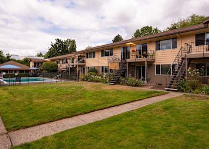 a view of a building with a yard and a pool