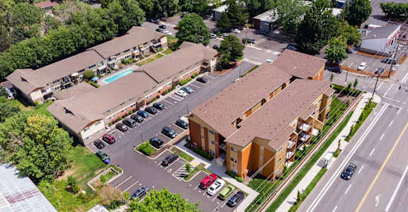 an aerial view of a building with cars parked in a parking lot
