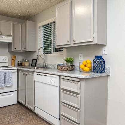 A kitchen with white appliances and cabinets.