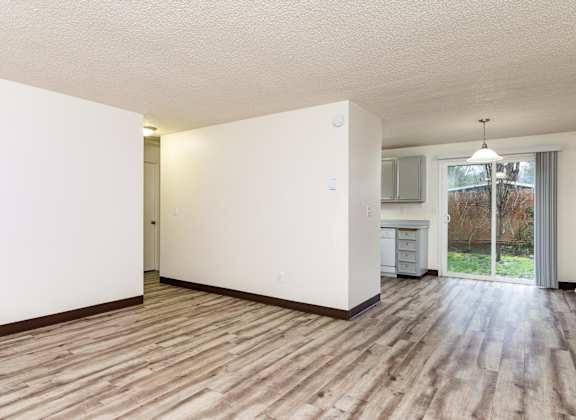 A room with wooden flooring and white walls.