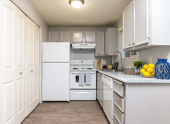 A kitchen with white appliances and cabinets.
