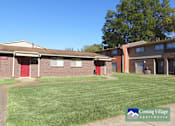 Thumbnail 3 of 7 - A sunny day at Corning Village Apartments with a clear blue sky.