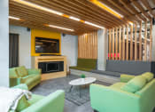Thumbnail 5 of 8 - a living room with green couches and a yellow fireplace