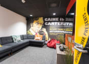 Thumbnail 3 of 8 - a large poster in the lobby of a building with a bunch of couches in front of
