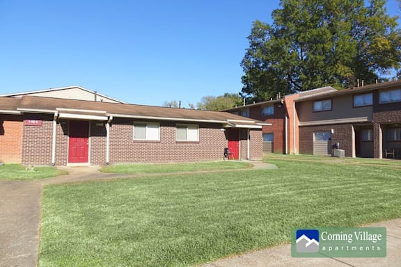 A sunny day at Corning Village Apartments with a clear blue sky.