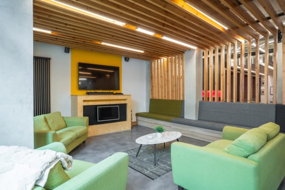 a living room with green couches and a yellow fireplace