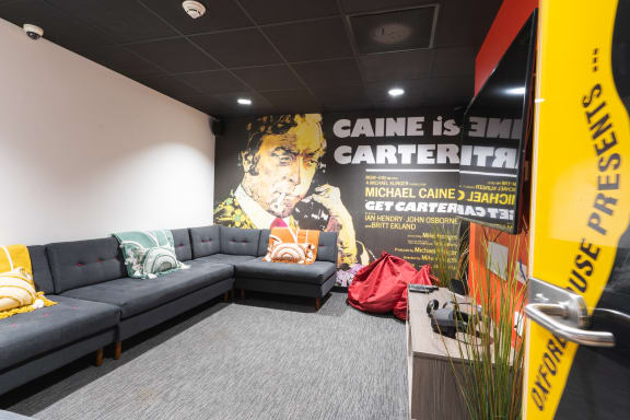 a large poster in the lobby of a building with a bunch of couches in front of