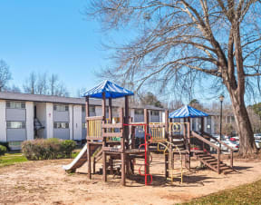 a playground with a swing set and a tree at Uphill Flats, Decatur, Georgia