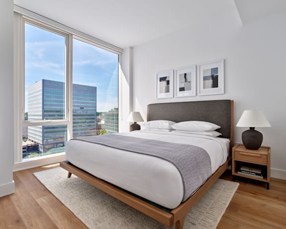 A bedroom with a large bed and a view of the city.