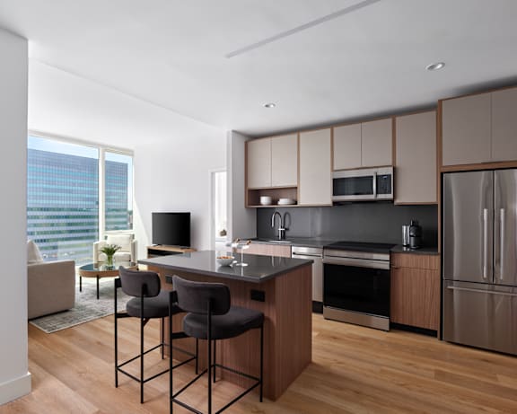 A modern kitchen with a bar area and two chairs.