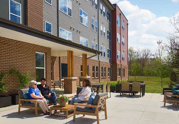 a group of people sitting in chairs outside of a building