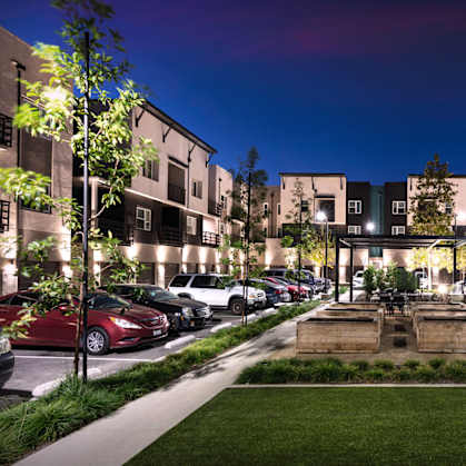 A parking lot with cars and a building in the background.