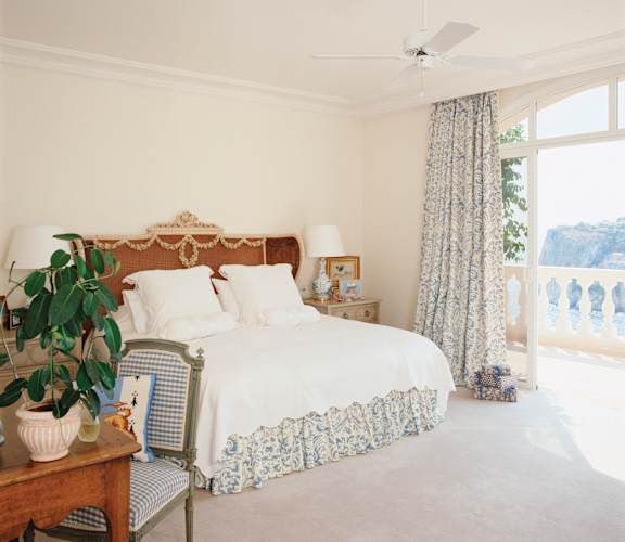 A bedroom with a bed, nightstand, chair, and a plant at Pleasantview Apartments, Baltimore, MD, 21214