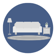 A white sofa sits next to a small table with a vase on it.
