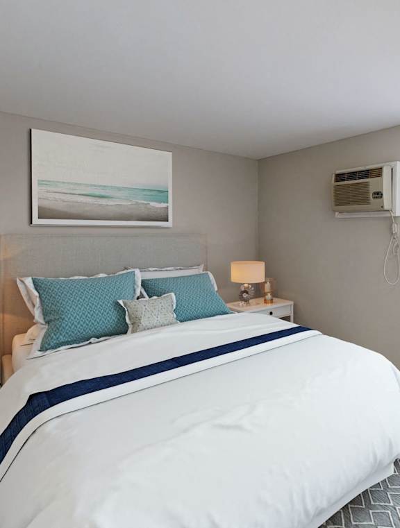 A bedroom with a large bed and a painting on the wall at Eton Square Apartments and Townhomes, Birmingham, MI