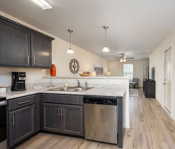 A kitchen with dark wood cabinets and a white countertop.