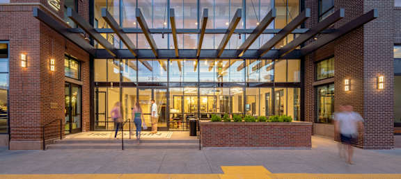 the entrance of a building with people walking in front of it