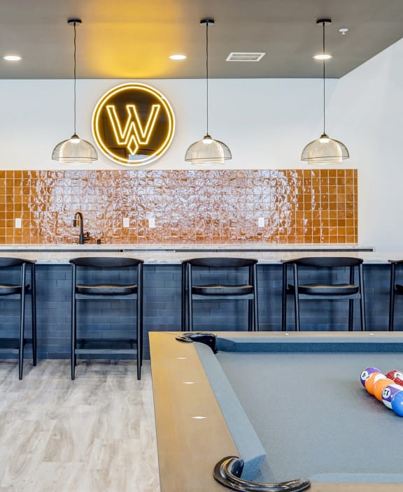 pool table and bar in clubhouse at the bradley braddock road station apartments