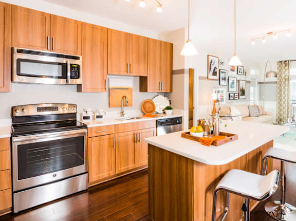 A modern kitchen with wooden cabinets and stainless steel appliances.