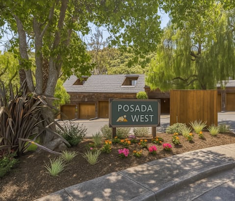 A sign that says Posada West is in front of a building.