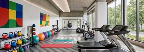 A group of people are exercising in a gym with treadmills and other equipment.