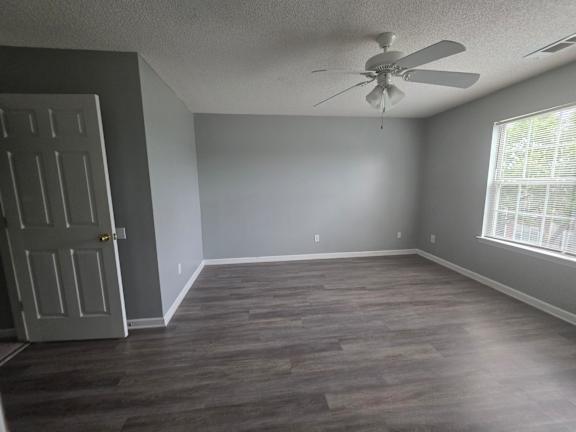 A room with a ceiling fan and a door.