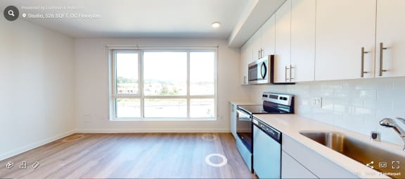 an empty kitchen with white cabinets and a window