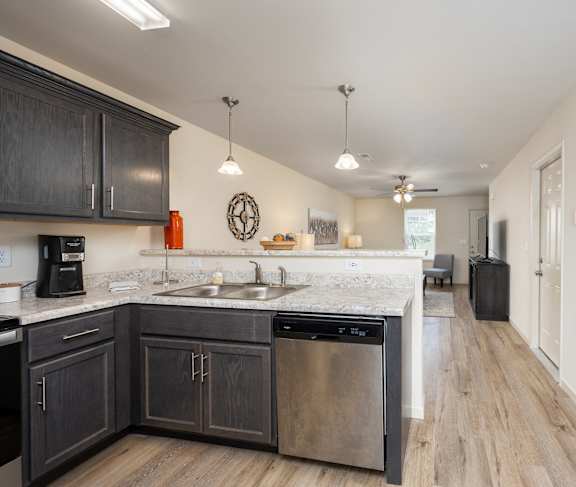 A kitchen with dark wood cabinets and a white countertop.