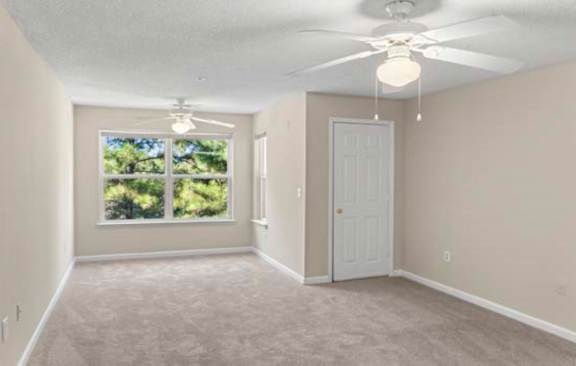A room with a ceiling fan and a door.
