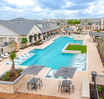 an aerial view of a swimming pool with chairs and umbrellas at Citadel at Westpointe, Texas, 78251