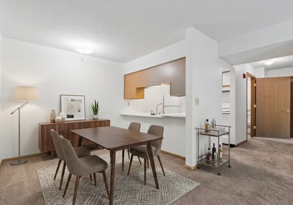 a dining room and kitchen with a table and chairs
