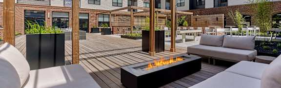 A patio with a fire pit and seating area.