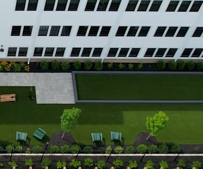 A large white building with a green lawn in front.