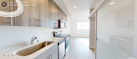 an empty kitchen with white cabinets and a stainless steel sink
