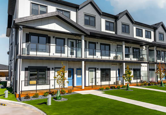 A row of townhouses with blue doors and windows.at Latitude 49 Townhomes, Winnipeg, MB R3X 0M1