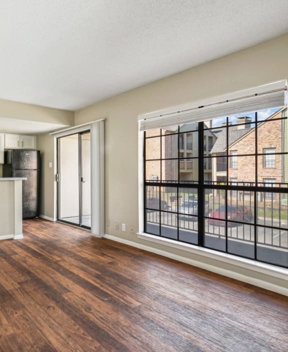 Spacious living room with large windows at Bandera Crossing apartments in San Antonio, TX