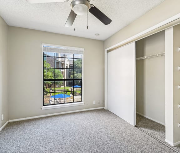 Bright bedroom with a big window at Bandera Crossing apartments in San Antonio, TX
