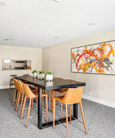 Clubhouse dining area with tall table and seats next to kitchen at Bandera Crossing apartments in San Antonio, TX