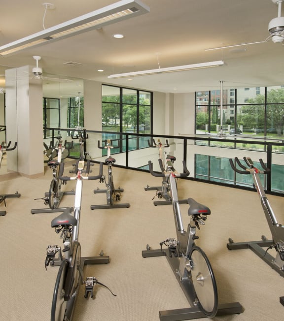 a gym with exercise bikes and a view of a pool