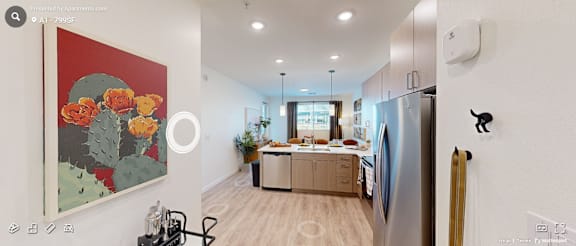 A kitchen with a refrigerator, a painting on the wall, and a dining table with chairs.