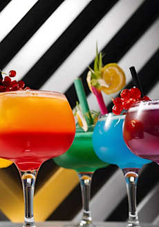 a row of colorful glasses filled with different colored drinks