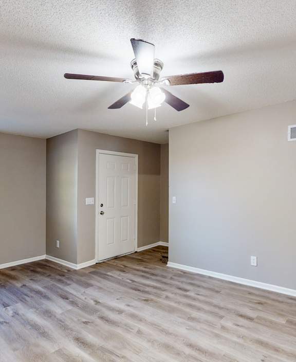 an empty room with a ceiling fan and a window