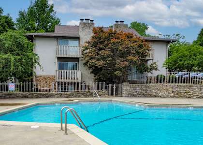 a swimming pool in front of an apartment building with a pool