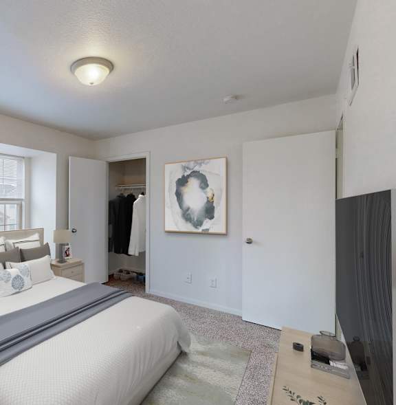 A bedroom with a large bed and a painting on the wall.