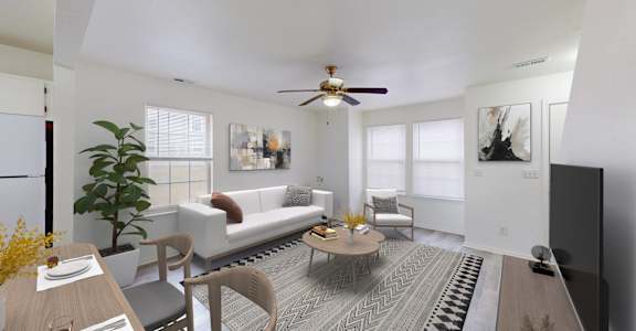 A living room with a white couch, a coffee table, and a ceiling fan.