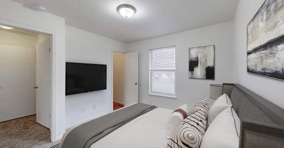 A bedroom with a large bed and a flat screen TV.